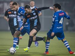 Cas Peters (m.) probeert zich door de defensie van PEC Zwolle te wurmen. Bart Schenkeveld (l.) kan in het duel meegaan, Dirk Marcellis moet Peters laten passeren. (05-03-2016)