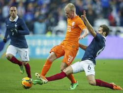 Davy Klaassen (m.) probeert Yohan Cabaye (r.) van de bal af te houden terwijl Franck Ribéry (l.) toekijkt. (5-3-2014)