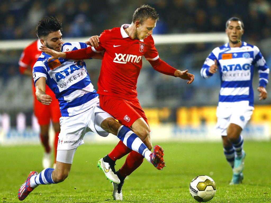 Robin Pröpper (l.) probeert Dico Koppers (r.) van de bal te zetten tijdens het bekerduel De Graafschap - FC Twente. (17-12-2014)