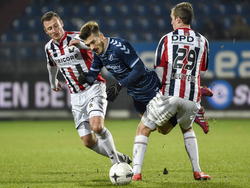 FC Utrecht-aanvaller Édouard Duplan (m.) gaat over het been bij Stijn Wuytens (r.), terwijl Jonas Heymans (l.) toekijkt. (04-02-2015)