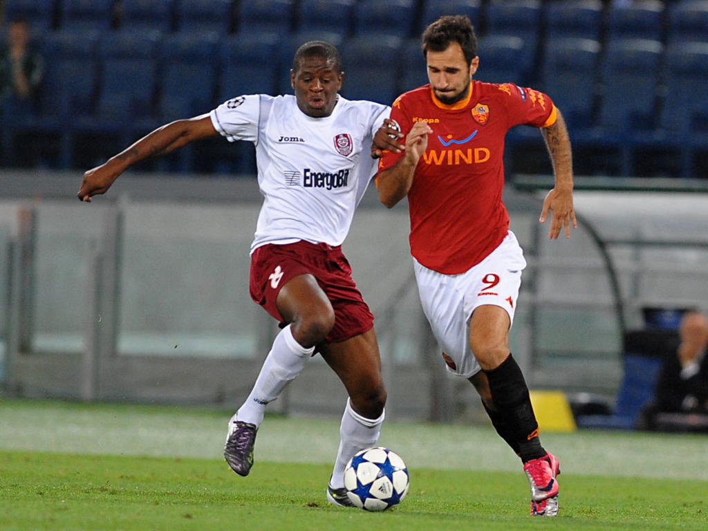 Dominique Kivuvu (l.) probeert Mirko Vučinić (r.) de bal te ontfutselen tijdens AS Roma - CFR Cluj. (28-09-2010)