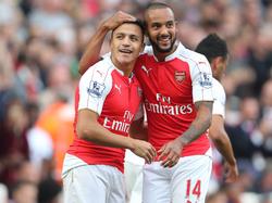 Alexis Sánchez (l) en Theo Walcott vieren samen de overwinning van Arsenal op Manchester United. (04-10-2015)