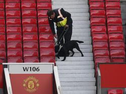 Een speurhond van de politie ruikt aan een pakketje op Old Trafford. Het competitieduel tussen Manchester United en Bournemouth kan geen doorgang vinden. (15-05-2016)