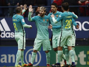 Lionel Messi (m.) is het middelpunt van de feestvreugde. De aanvaller scoort tweemaal tegen Osasuna. (10-12-2016)