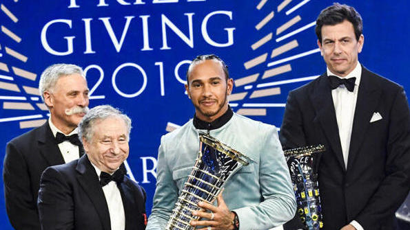 Lewis Hamilton hält den Weltmeister-Pokal in seinen Händen Lewis Hamilton hält den Weltmeister-Pokal in seinen Händen