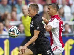 Anwar El Ghazi (r.) probeert voor Mark Engberink (l.) te kruipen, maar de Heracles-verdediger houdt zijn lichaam goed tussen de bal en de man. (13-09-2014)