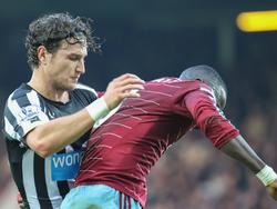 Daryl Janmaat (l.) vecht een duel uit met Cheikhou Kouyate (r.) tijdens het competitieduel West Ham United - Newcastle United. (29-11-2014)