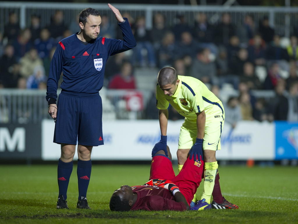 Scheidsrechter Vladimir Vnuk laat verzorgers komen voor Barcelona keeper A1 doelman André Onana. (04-11-14)