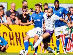 Kevin Diks (m.) kleunt erin in het vriendschappelijke duel tegen Schalke 04. Alessandro Schöpf (l.) vangt de Nederlander. (07-08-2016)