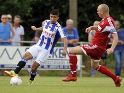 Bilal Başaçikoğlu (l.) probeert Sander Keller (r.) voorbij te spelen tijdens de oefenwedstrijd sc Heerenveen - Almere City. (13-7-2014)