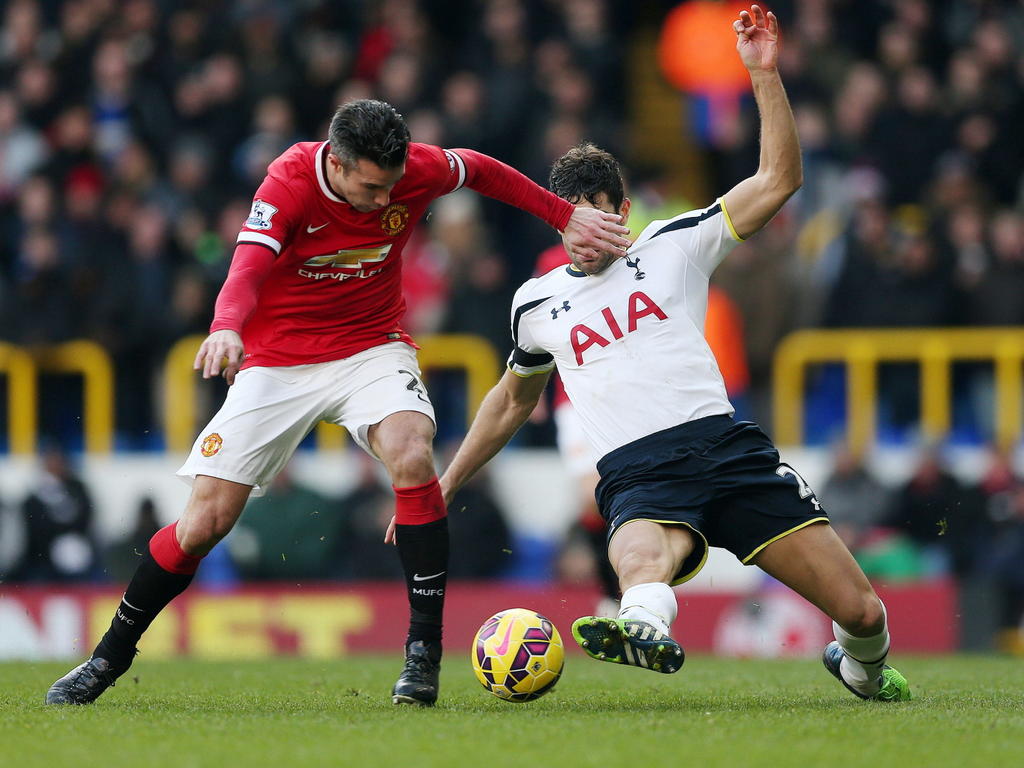 Federico Fazio (r.) probeert met een sliding de bal voor de voeten van Robin van Persie (l.) weg te tikken tijdens de wedstrijd Tottenham Hotspur - Manchester United. (28-12-2014)