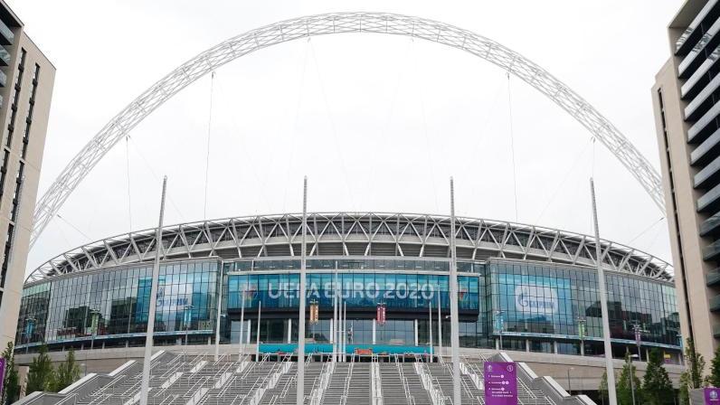 Passanten gehen über den Platz vor dem Wembley-Stadion