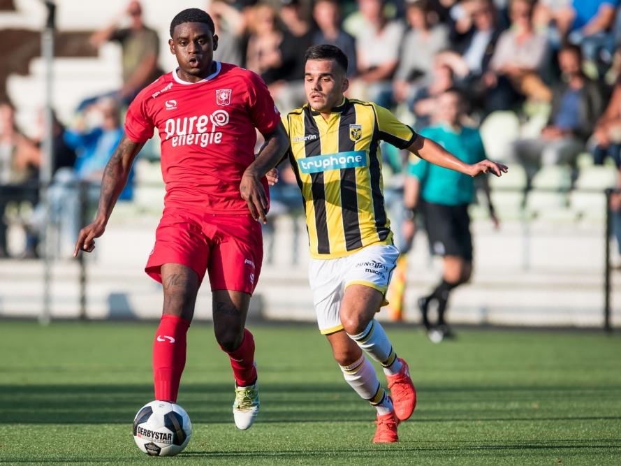 Kyle Ebecilio (l.) kijkt vooruit met de bal aan de voet, maar Anıl Mercan (r.) maakt zich klaar voor de onderschepping tijdens Jong Vitesse - Jong FC Twente. (22-08-2016)