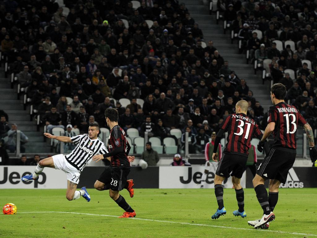 Stefano Sturaro (l.) doet zijn uiterste best om bij een lage voorzet te komen, terwijl spelers van AC Milan toekijken. (21-11-2015)