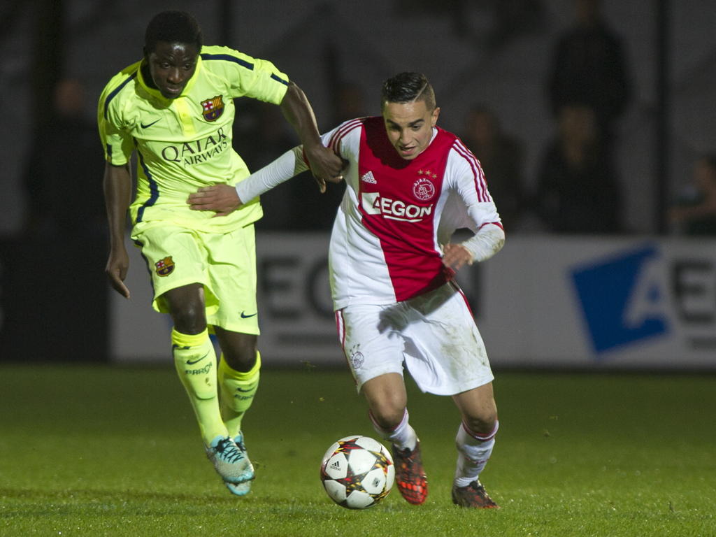 Abdelhak Nouri (r.) houdt Zacharie Enguene van zich af tijdens Ajax - FC Barcelona. (04-11-2014)