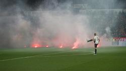 Dichte Rauchschwaden durchziehen das Mainzer Stadion, nachdem Feuerwerkskörper aus dem Gästeblock auf dem Rasen gelandet sind