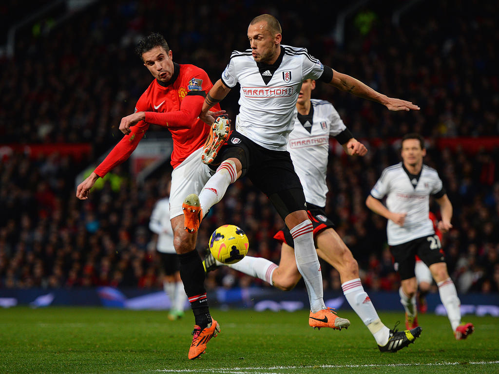 John Heitinga (r.) en Robin van Persie (l.) strijden om de bal tijdens Manchester United - Fulham. (9-2-2014)