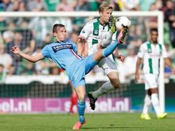 Met het been hoog in de lucht probeert zowel Stijn Wuytens (l.) als Rasmus Lindgren (r.) de bal te raken. (28-09-2014)