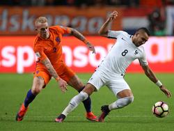 Rick Karsdorp (l.) vecht een duel uit met Dimitri Payet (r.) tijdens het WK-kwalificatieduel van het Nederlands elftal met Frankrijk. (10-10-2016)