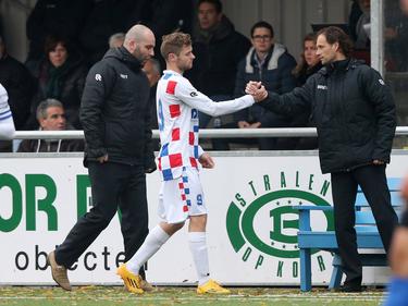 Dennis Kaars (m.) krijgt een hand van assistent-trainer Olaf Lindenbergh (r.) tijdens het competitieduel De Dijk - Jong FC Den Bosch (13-11-2016).