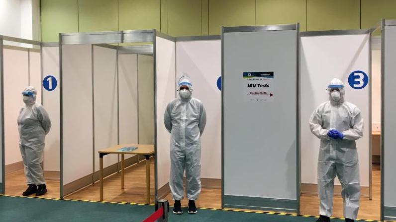Helfer stehen in einem Corona-Testzentrum der IBU für Tests im Rahmen des Hygiene-Konzepts bereit Helfer stehen in einem Corona-Testzentrum der IBU für Tests im Rahmen des Hygiene-Konzepts bereit