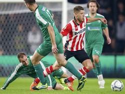 Stijn Schaars moet zien af te rekenen met een hand vol spelers van SC Genemuiden tijdens het bekerduel PSV - SC Genemuiden. (27-10-2015)