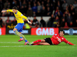 Mesut Özil (l.) bereitete zwei Treffer der Gunners in Cardiff vor