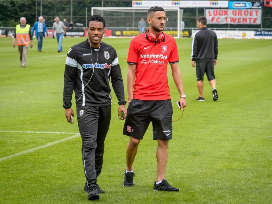 Garry Rodrigues (l.) en Hakim Ziyech (r.) lopen samen over het veld voorafgaand aan het vriendschappelijke duel tussen PAOK Saloniki en FC Twente. (16-07-2016)