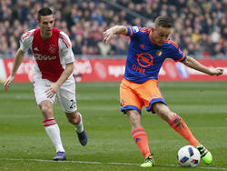 Met een droge schuiver in de lange hoek zorgt Jens Toornstra (r.) ervoor dat Feyenoord op voorsprong komt tegen Ajax. (07-02-2016)