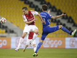 In de oefenwedstrijd Ajax - Schalke 04 springt Arkadiusz Milik (l.) de lucht in en de Poolse spits van Ajax zet zijn hoofd tegen de bal. Roman Neustadter timet verkeerd en komt niet bij de bal. (10-01-2015)