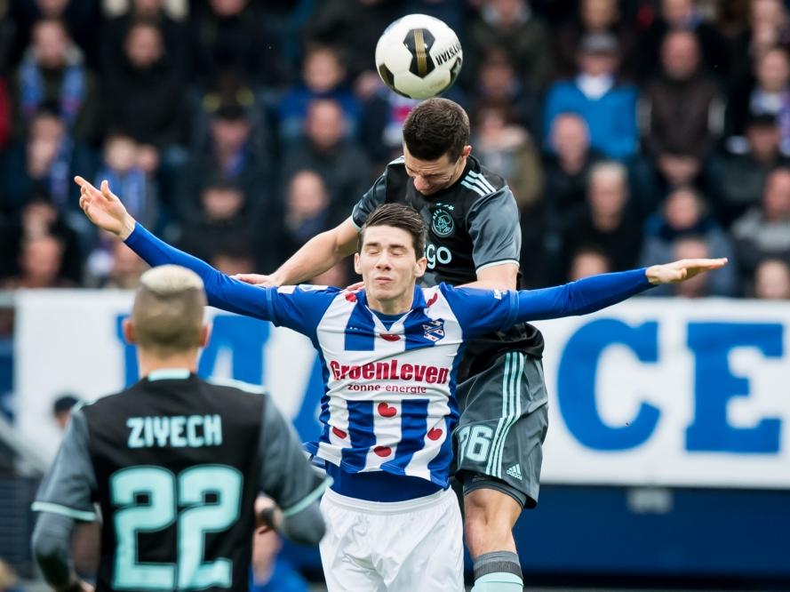 Sc Heerenveen-middenvelder Pelle van Amersfoort verliest een kopduel van Ajax-verdediger Nick Viergever. Hakim Ziyech kijkt op de voorgrond toe. (27-11-2016)