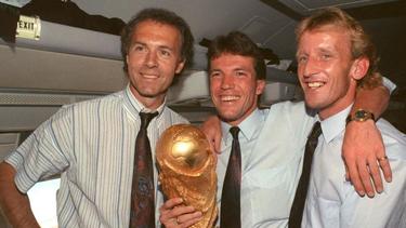 Heimflug mit Pokal: Teamchef Franz Beckenbauer (l.), Lothar Matthäus (M.) und Andreas Brehme feiern den WM-Sieg 1990