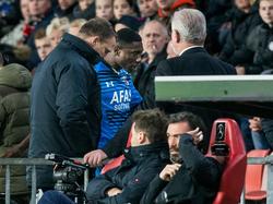 John van den Brom (l.) neemt Derrick Luckassen (r.), die zojuist in het duel met PSV een rode kaart heeft gekregen, in bescherming. De trainer begeleidt de jonge verdediger van AZ naar de kleedkamer. (29-11-2015)