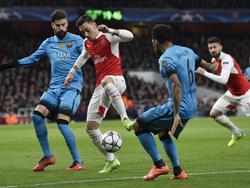 Piqué (l.) zet samen met teamgenoot Dani Alves (r.) Mesut Özil onder druk tijdens de Champions League-wedstrijd tussen Arsenal en FC Barcelona. (23-02-2016)