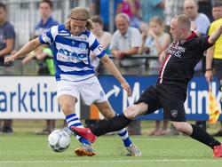 Thijs Bouma (l.) ontwijkt handig een sliding van Patrick van Haren (r.) tijdens een oefenwedstrijd van De Graafschap tegen VIOD. (04-07-2015)