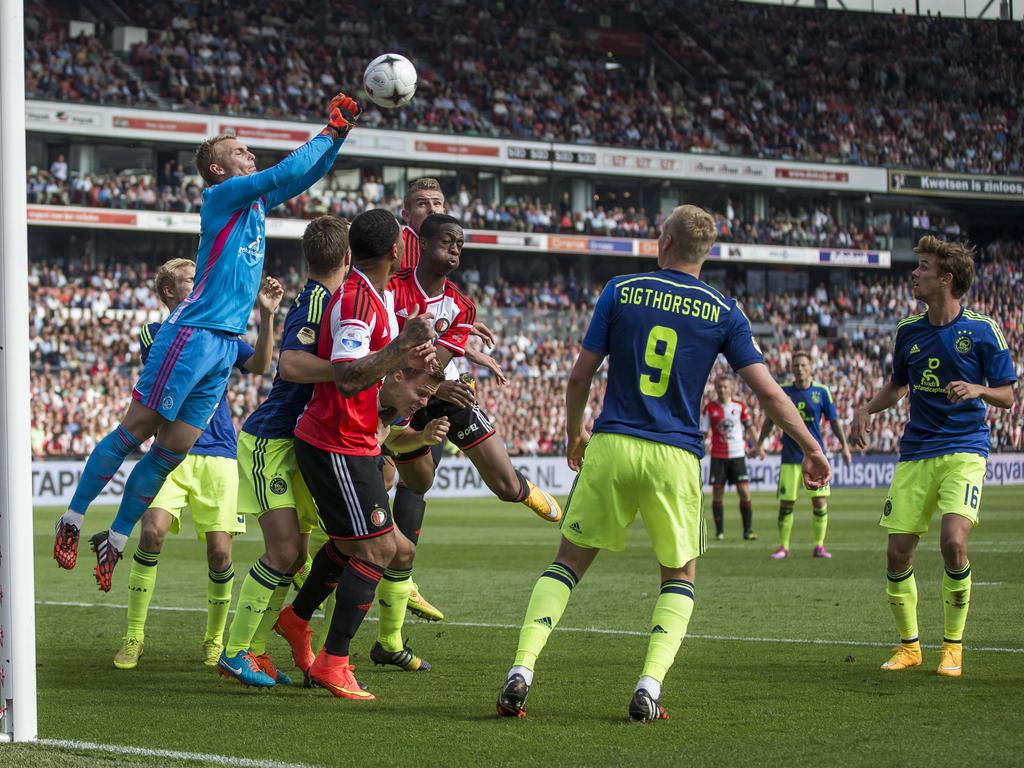 Jasper Cillessen (keeper) bokst de bal weg tijdens Feyenoord - Ajax en voorkomt dat drie Feyenoorders gevaarlijk worden. (21-09-2014)