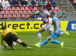 Het moment van de 2-1 bij FC Utrecht - Willem II. Leon de Kogel (m.) tikt de bal achter David Meul (l.). Frank van der Struijk (r.) is te laat bij de bal om een treffer te voorkomen. (17-08-2014)