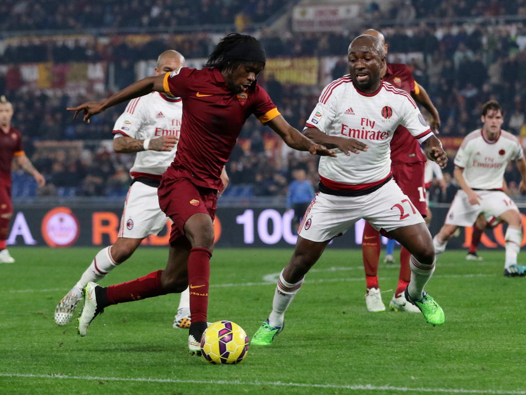 Gervinho van AS Roma (l.) maakt de actie en AC Milan-speler Pablo Armero (r.)probeert de bal te blokken. (20-12-2014)