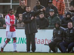 Wim Jonk (m.) is druk bezig met het geven van aanwijzingen tijdens de mini-Klassieker tussen Feyenoord A1 en Ajax A1. Bryan Roy (r.) zit verkleumd op de bank. (30-11-2014)