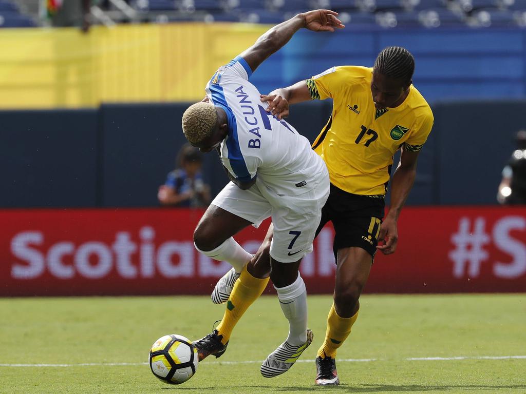 Leandro Bacuna (l.) vecht een duel uit met Kevon Lambert (r.) tijdens het duel in de Gold Cup tussen Curaçao en Jamaica (10-07-2017).