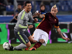 Radja Nainggolan (r.) raakt niet alleen de bal, maar ook de benen van Cristiano Ronaldo (l.) tijdens het Champions League-duel AS Roma - Real Madrid. (17-02-2016)