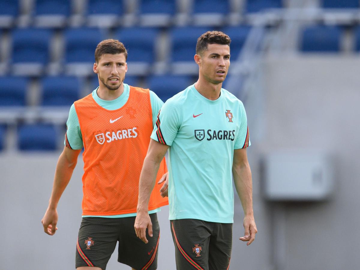Portugals Cristiano Ronaldo (r) und Ruben Dias stehen während des Trainings nebeneinander