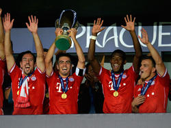 Philipp Lahm hebt als Bayern-Kapitän als Erster den soeben gewonnenen UEFA-Supercup in den Prager Nachthimmel
