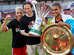 Ende gut, fast alles gut. Roger Schmidt mit dem Cup-Pokal in den Händen, flankiert von Kevin Kampl und Alan samt Meisterschale.