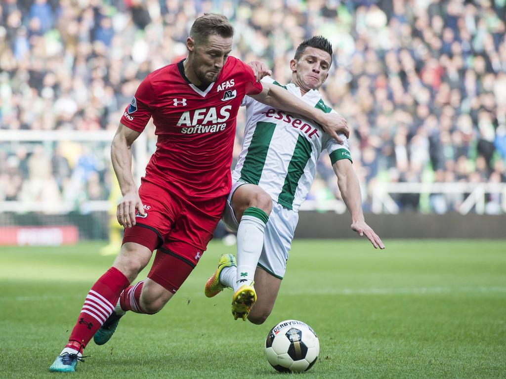 Bryan Linssen (r.) zet alles op alles om Rens van Eijden (l.) af te stoppen in het duel FC Groningen - AZ. (23-10-2016)