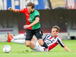 Stijn Wuytens (r.) raakt met zijn tackle niet alleen de bal, maar ook de benen van Christian Santos (l.) tijdens de wedstrijd Willem II - NEC. (28-08-2015)