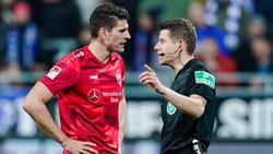 Mario Gomez (l.) spricht mit Referee Patrick Ittrich nach einer Abseitsentscheidung