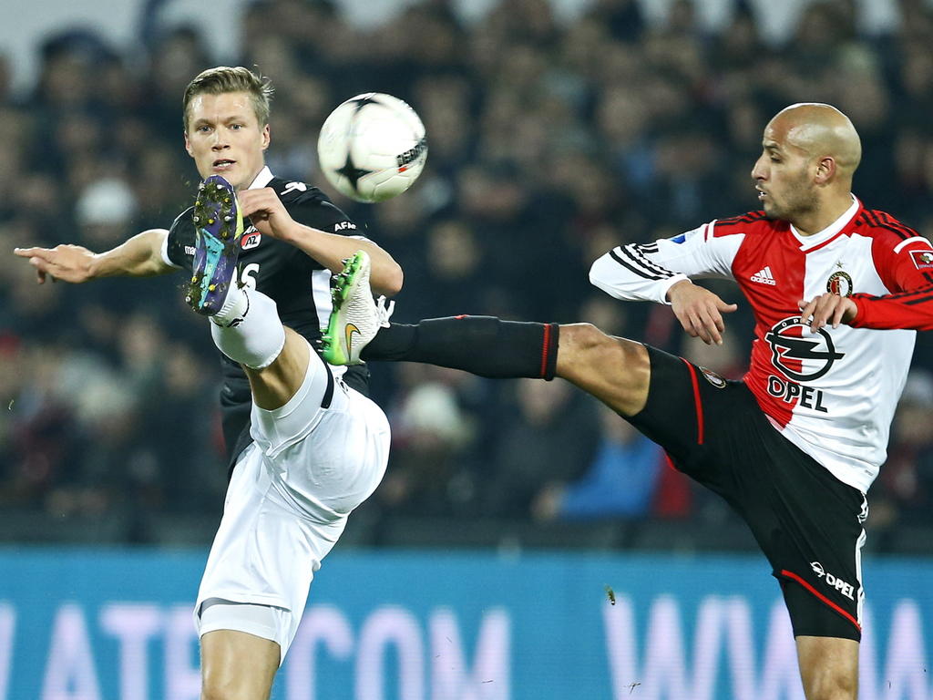 Viktor Elm (l.) en Karim El Ahmadi (r.) gaan beiden op een riskante manier voor de bal tijdens het duel tussen Feyenoord en AZ. (14-12-2014)