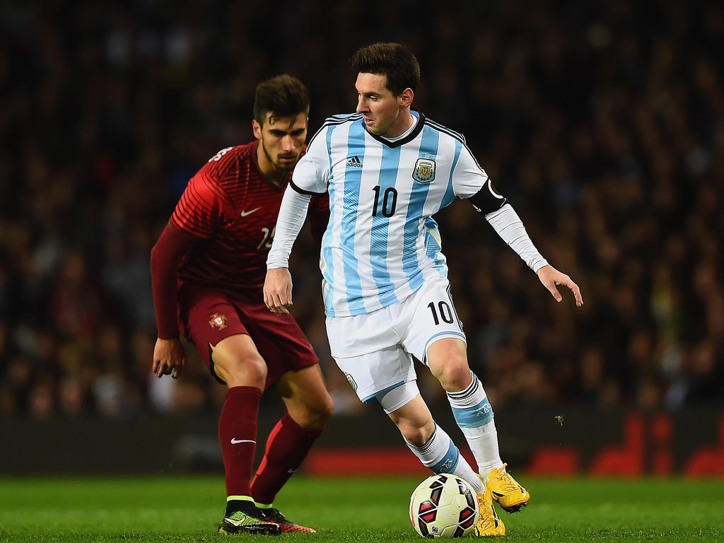Lionel Messi (r.) is in het vriendschappelijke duel tegen Portugal niet van de bal te krijgen door Andre Gomes (l.). (18-11-2014)