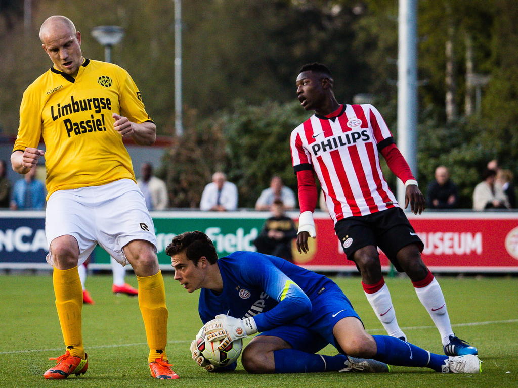 Frank Demouge (l.) hoopte een voorzet binnen te koppen tegen Jong PSV, maar doelman Jesse Bertrams (m.) kan het speeltuig klemmen. Hierdoor hoeft Augstine Loof (r.) niet in te grijpen. (20-04-2015)